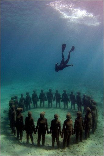 Diver inspecting underwater sculptures in Cancun